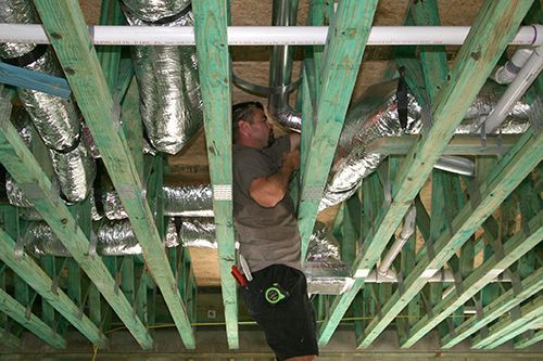 Service technician repairing commercial ductwork.